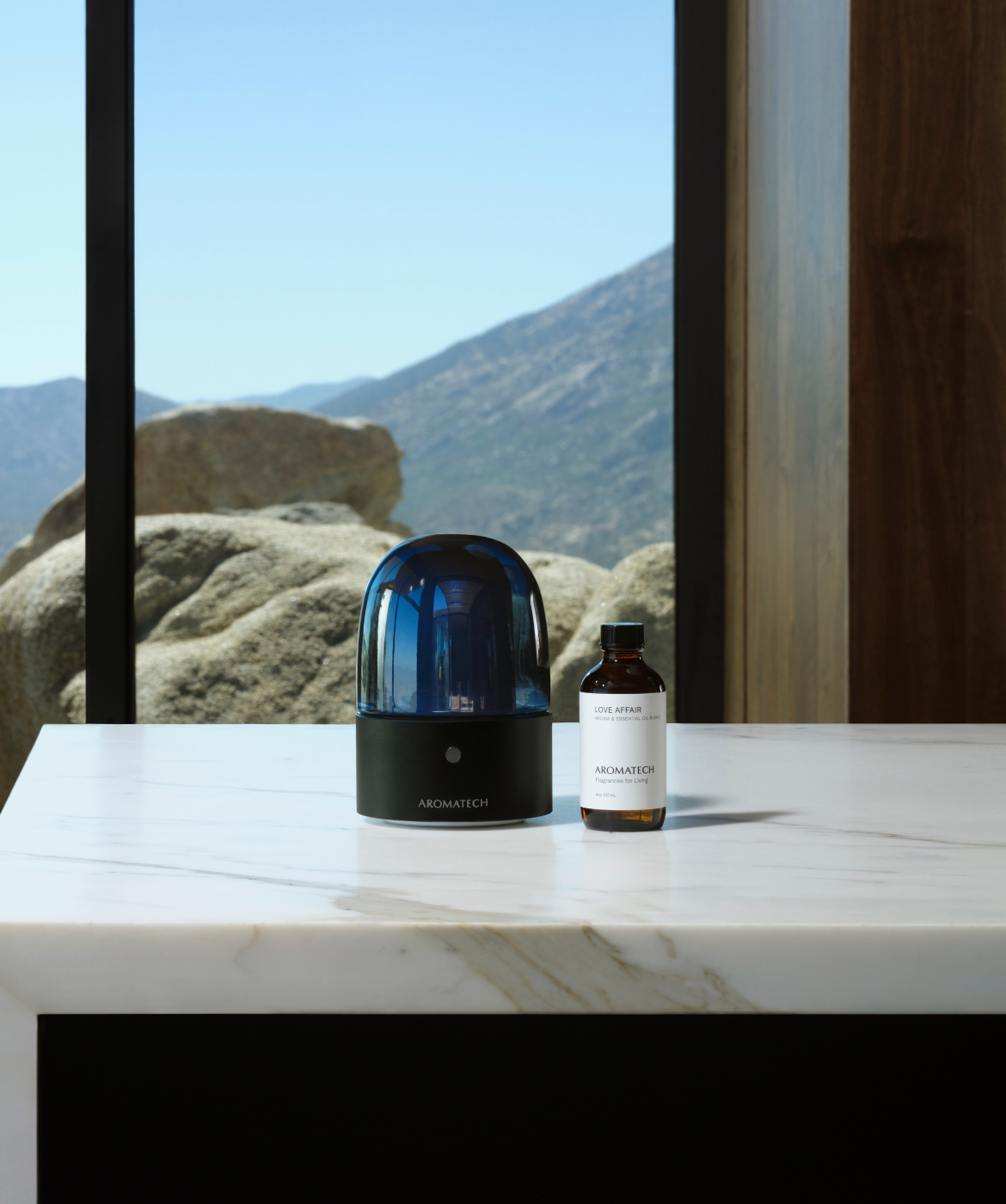 AromaDream diffuser on a stone table, overlooking scenic mountain views